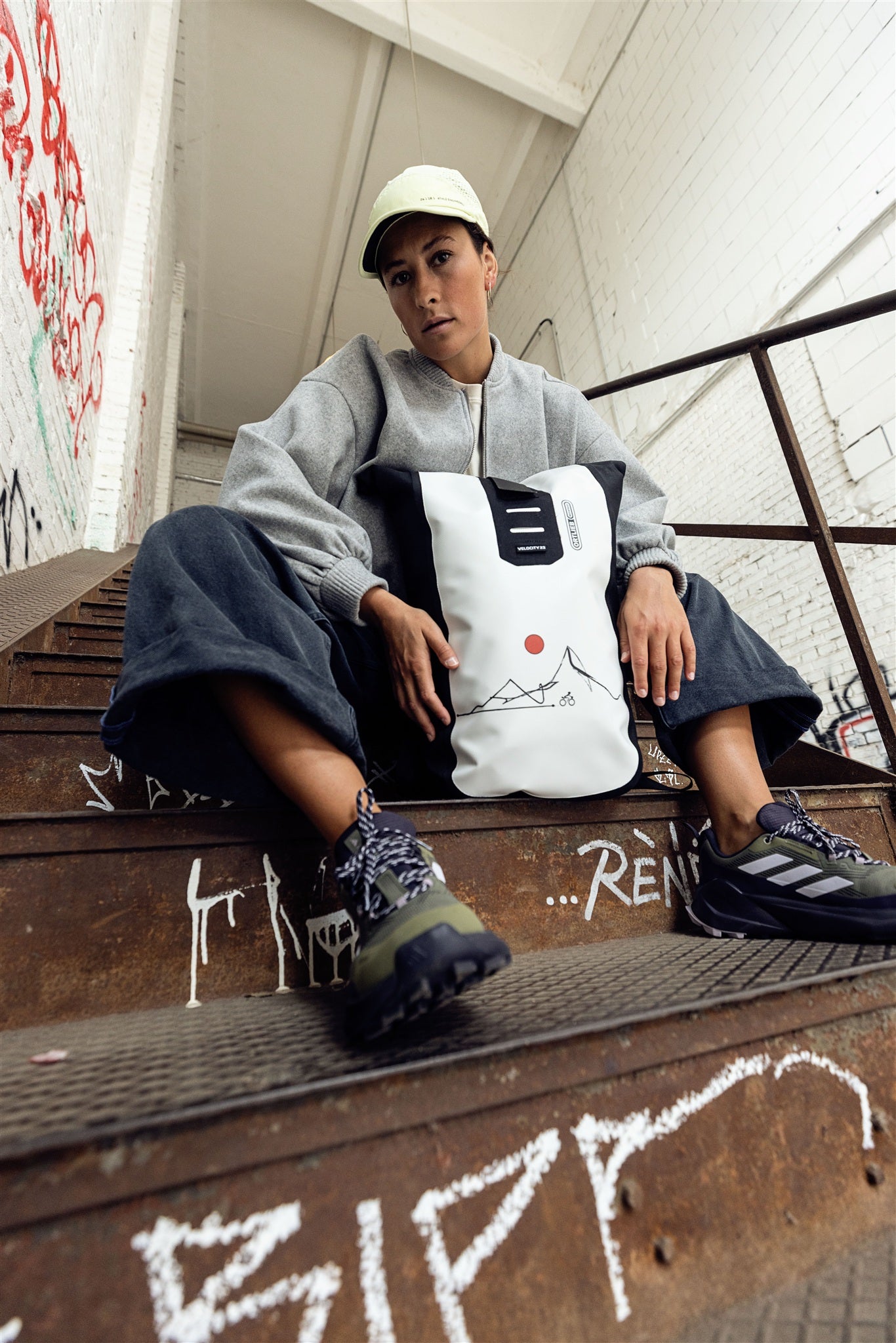 Person cycling in urban environment wearing white black ORTLIEB Velocity Design backpack