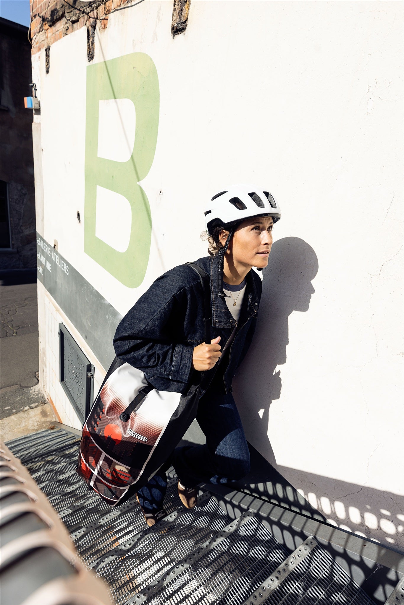 Bicycle with mounted ORTLIEB Back-Roller Design bag in design "Morning Routine" leaning against bright wall