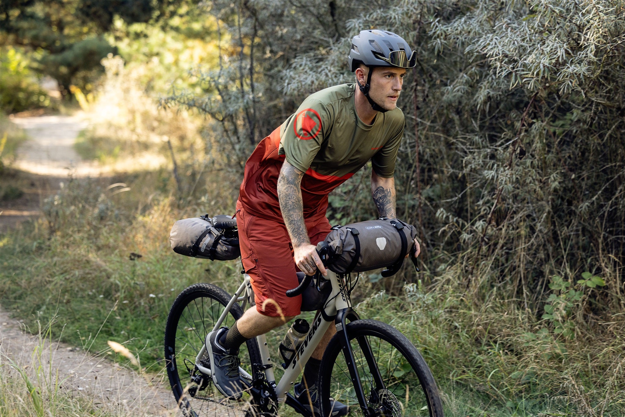 Cyclist attaching ORTLIEB Handlebar-Pack Flex in dark-sand to handlebar off-road